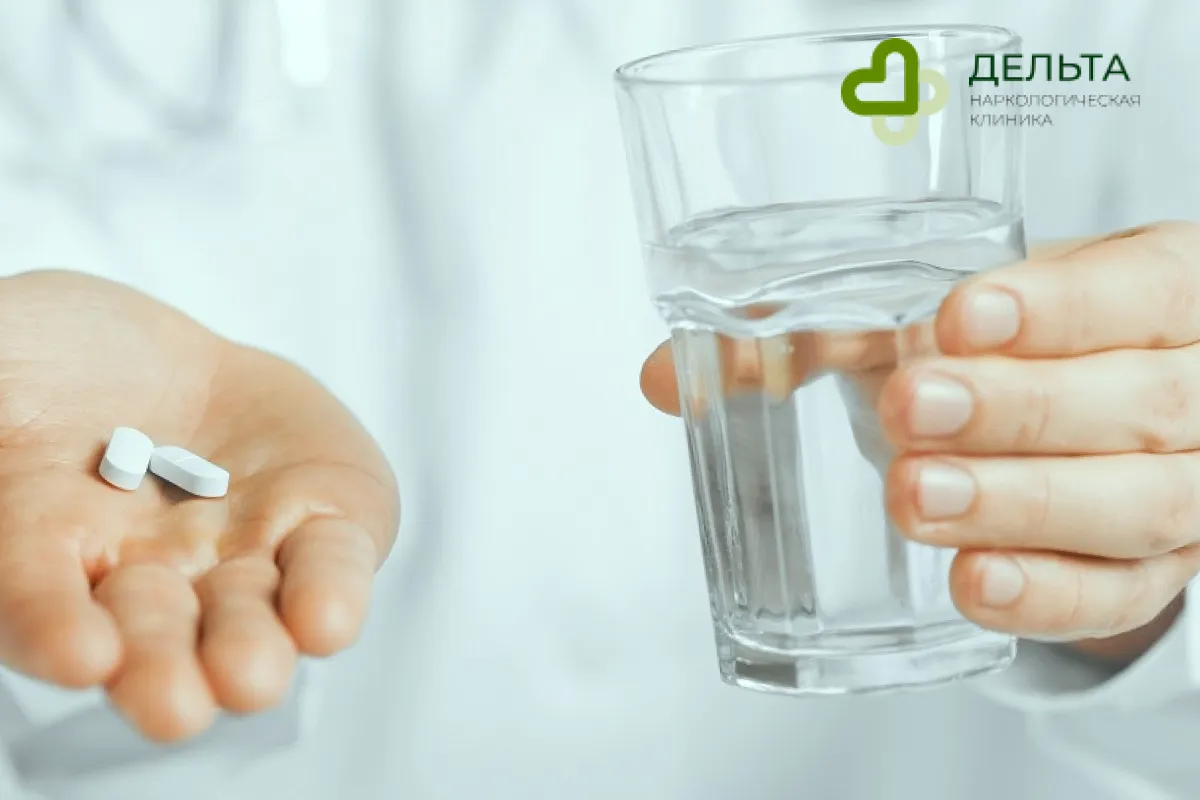 Человек с таблетками и стаканом воды